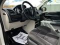Interior view of a 2011 Dodge Grand Caravan showing the steering wheel dashboard and front seats with a thank you mat on the floor
