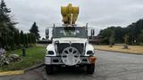 A 2006 International 7500 truck with a yellow boom lift attached at the top and a large circular attachment on the front