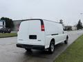 A white 2014 GMC Savana van viewed from the rear with a plain rear door and no visible license plate