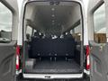 A 2021 Ford Transit with a spacious interior featuring several rows of seats and overhead lighting