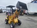 A yellow 2024 AGT KRW 23 Mini loader with a raised front bucket and four large wheels, designed for compact loading tasks
