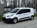 A 2016 Ford Transit Connect van in white with black accents parked on a concrete surface