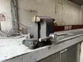 A heavy-duty metal bench vice with a sturdy base and a large handle designed for securing workpieces in place during manual tasks