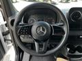 The steering wheel of a 2019 Mercedes-Benz Sprinter with control buttons and the Mercedes-Benz emblem prominently displayed