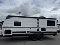 A 2022 Keystone Hideout RDWE 20RDWE travel trailer featuring a sleek white exterior with black accents and dual axles