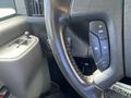 Close-up of the steering wheel and controls of a 2022 GMC Savana showcasing buttons for cruise control and vehicle settings
