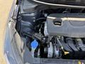 An open hood of a 2018 Kia Rio5 revealing the engine compartment with various components including the engine, a coolant reservoir, and belts