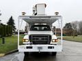 A 2015 Ford F750 truck with a large service platform and multiple lights mounted on top facing forward