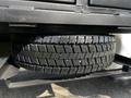 A spare tire mounted underneath a 2016 Ford F-550 with a rugged tread pattern visible