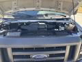 Engine compartment of a 2008 Ford E-350 with the hood raised showing various components like the air intake and fluid reservoirs