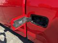A close-up of the fuel filler door on a red 2018 GMC Canyon revealing the fuel cap and surrounding area