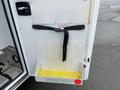 A door of a 2016 Chevrolet Express with a yellow step and a black strap attached to the interior panel