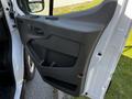 The interior side of the driver's door of a 2022 Ford Transit featuring a gray panel with a handle and control buttons