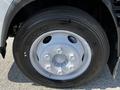 Close-up of a Michelin tire mounted on a silver wheel of a 2016 Isuzu NPR showing the tread and wheel design
