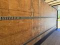 The interior of a 2015 Freightliner M2 106 truck featuring a wooden wall with a metal air vent running along the center