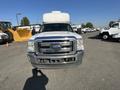 White 2014 Ford F-350 SD with a flat front and chrome grille visible in the foreground