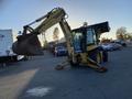 A yellow 2007 Komatsu WB156PS-5 backhoe loader with a front bucket and rear excavator arm positioned for work
