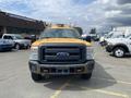 A yellow 2013 Ford F-250 Super Duty with a black grille and front bumper parked in a lot facing the camera