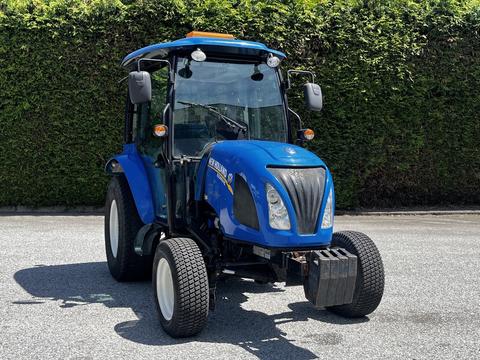 A 2018 New Holland Boomer 45 tractor with a blue exterior and black tires is shown in the foreground