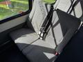 A grey fabric bench seat with a seatbelt in a 2021 Ford Econoline vehicle