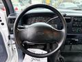 The interior of a 2001 Ford F-350 featuring a black steering wheel and a dashboard with various gauges and controls