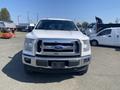 A 2017 Ford F-150 pickup truck with a white exterior facing the camera showcasing its front grille and headlights