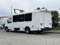 A white 2020 Chevrolet Express bus with multiple windows and a rear door parked on a concrete surface