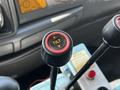 A close-up view of a black and red tilt control lever in the cabin of a 2009 Ford LCF 550 with directional arrows on the button