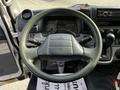 Dashboard and steering wheel of a 2015 Mitsubishi Fuso FE with two gauges visible and various controls on the console