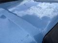 The surface of a blue 2010 Ford Econoline van showing scratches and wear with a shiny reflective finish