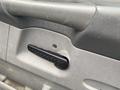 Close-up of the door handle mechanism of a 2008 Dodge Ram 5500 showing a textured black handle and a visible screw hole in the gray panel