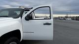 A white 2013 Chevrolet Silverado 1500 with an open driver's side door showcasing the vehicle's exterior and door handle