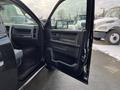 A 2015 RAM 1500 with an open driver's side door showing the interior features and controls