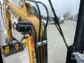 A yellow H13R mini excavator with a visible arm and attachment, showcasing controls and features from the operator's perspective
