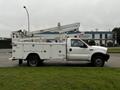 A 2004 Ford F-450 SD truck with a white utility body and an elevated bucket lift attached to the back