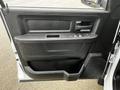 The interior door panel of a 2022 RAM 1500 Classic featuring a handle window controls and a storage compartment