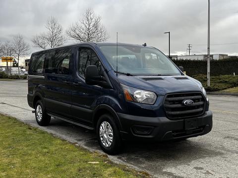 A blue 2020 Ford Transit van parked prominently with a streamlined design and large windows for passenger comfort