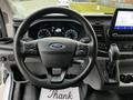 Steering wheel of a 2020 Ford Transit with control buttons and instrument display in the background