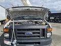 A 2008 Ford Econoline van with the hood open revealing the engine compartment and various components inside