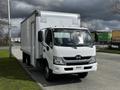 A 2018 Hino 195 truck with a white exterior and a box-style cargo area parked on a street