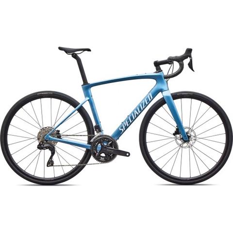 A blue 2026 Specialized Roubaix SL8 Comp Shimano 105 Di2 road bike featuring a sleek frame, drop handlebars, disc brakes, and gear components.