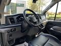 Interior view of a 2021 Ford Transit showing the steering wheel dashboard and driver's seat