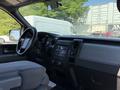 Interior view of a 2014 Ford F-150 showing the dashboard steering wheel and center console with controls