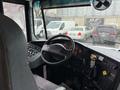 Interior view of a 2016 International CE300 bus showing the driver's seat steering wheel and control panel with gauges and switches