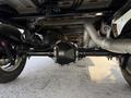 Underneath view of a 2021 Ford F-150 showcasing the rear axle assembly with suspension components and exhaust system visible