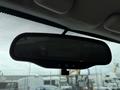 A rearview mirror in a 2012 GMC Canyon hanging from the windshield with buttons on the bottom and a darkened reflective surface