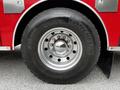 Close-up of a large black tire mounted on a shiny chrome wheel with multiple lug nuts featuring the Michelin logo