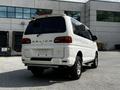 2003 Mitsubishi Delica 7 Passenger Van in white with a rear view showcasing its distinctive taillights and design features