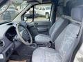 A 2013 Ford Transit Connect interior featuring two front seats with gray patterned upholstery and a dashboard with controls and instruments visible