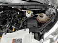 The engine compartment of a 2021 Ford Transit showing various components including the battery coolant reservoir and engine fluids